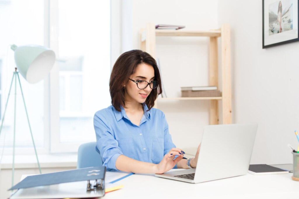 Female businessperson working on laptop in her remote office typing problem statement