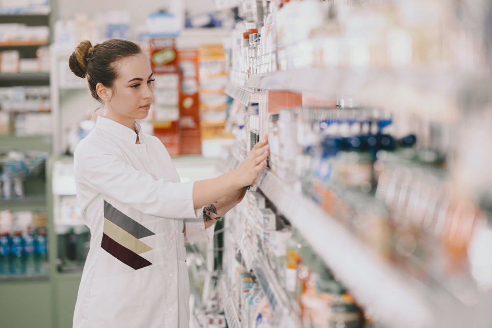 female pharmacist taking medications from the shelf