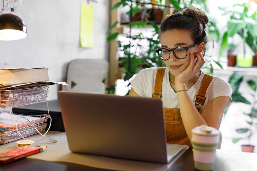 female graphic designer sitting in a room with plants