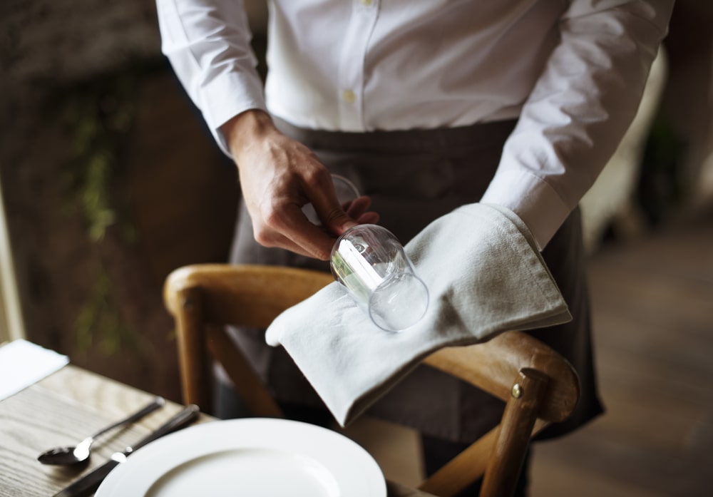 server wiping a wine glas in a fine dining restaurant
