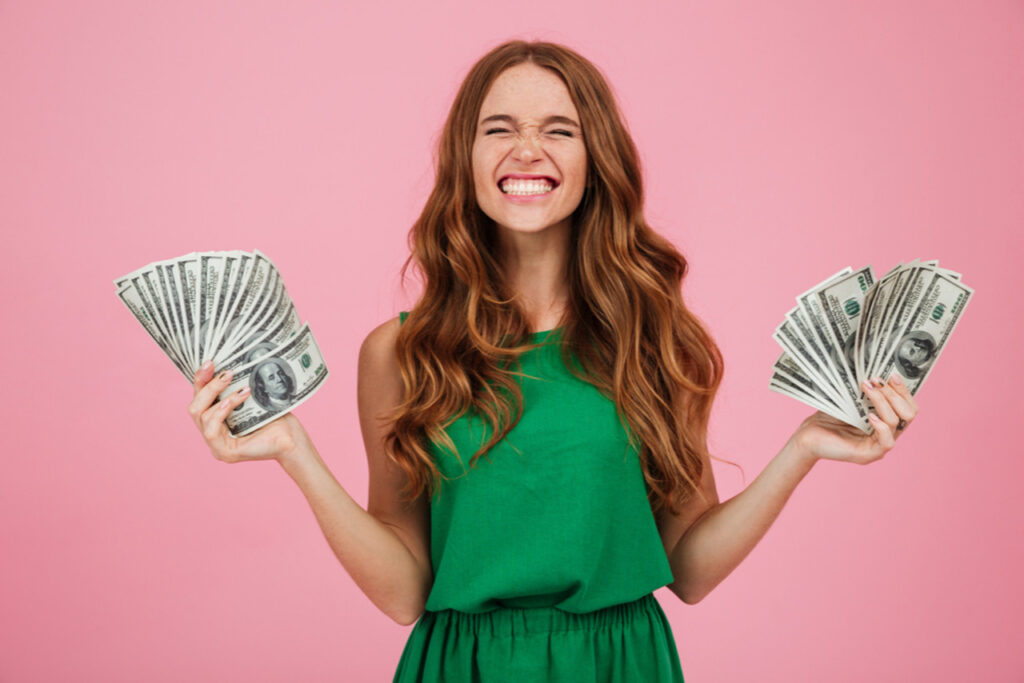 Portrait of a satisfied happy woman holding dollar bills