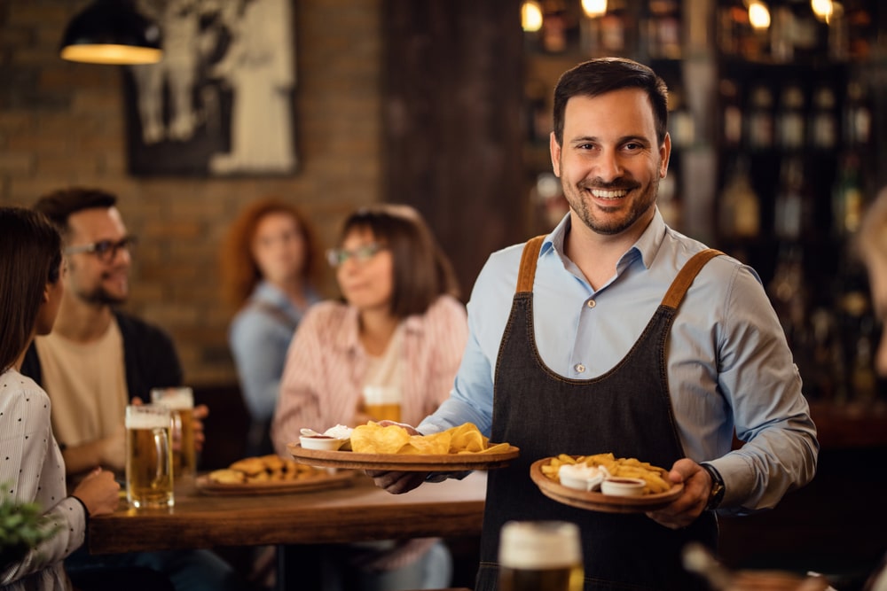 friendly male waiter serving food