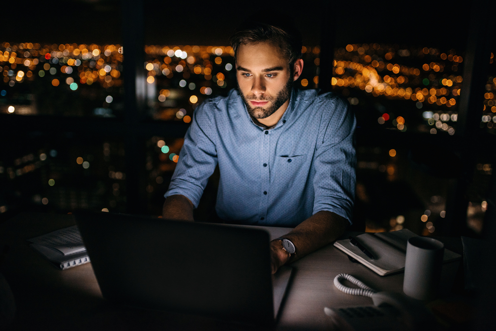 man looking at laptop late at night