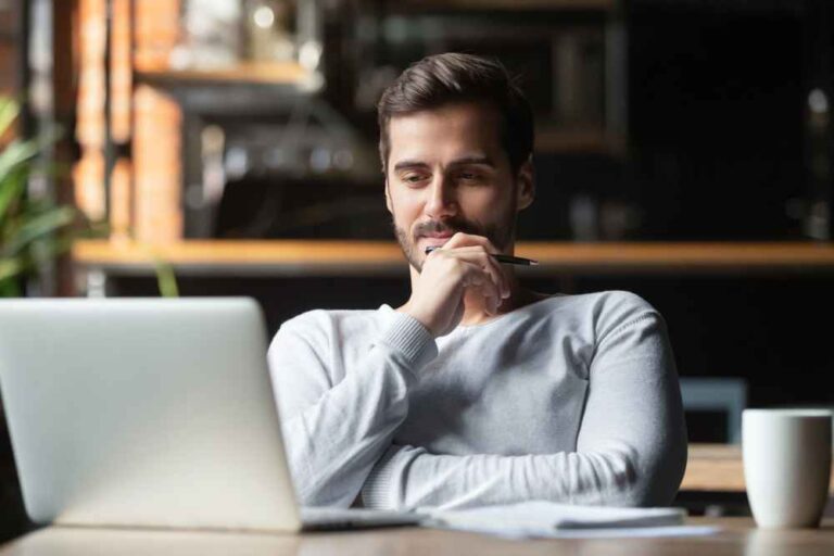 Person in front of laptop thinking about the five elements to write effective emails