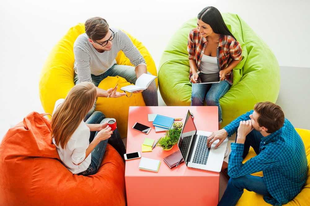 young people are sitting on colorful seats