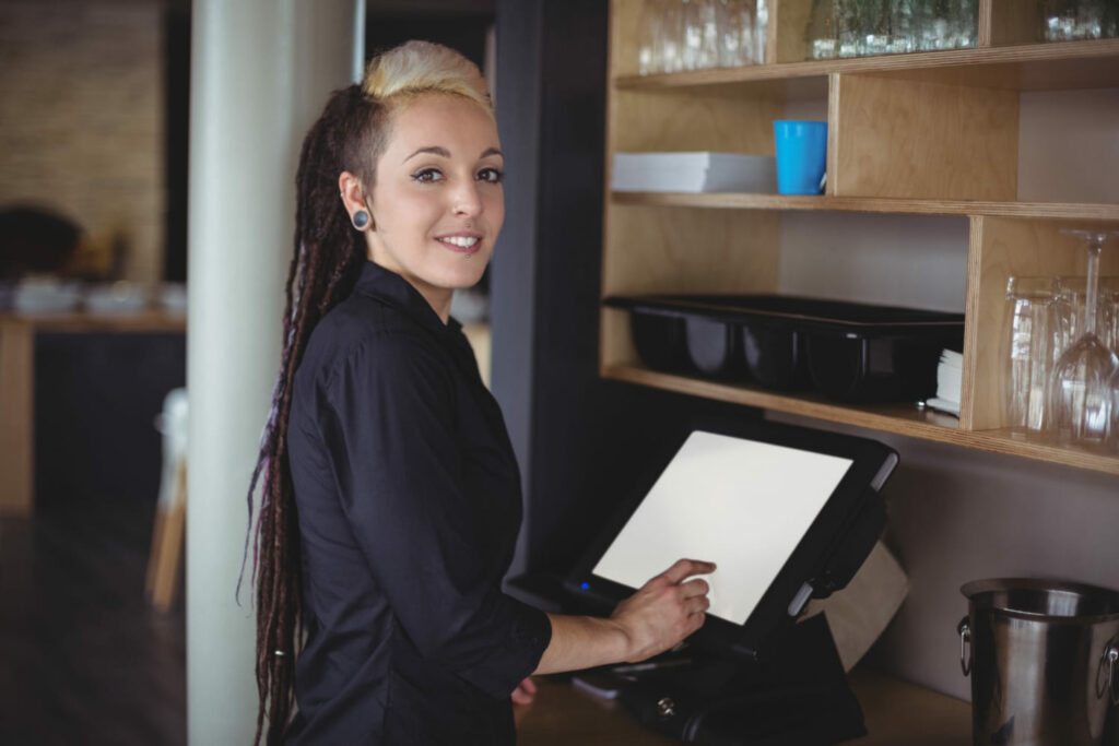 Female restaurant server using the cash register