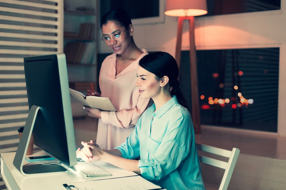 Pleasant female boss standing next to her colleague