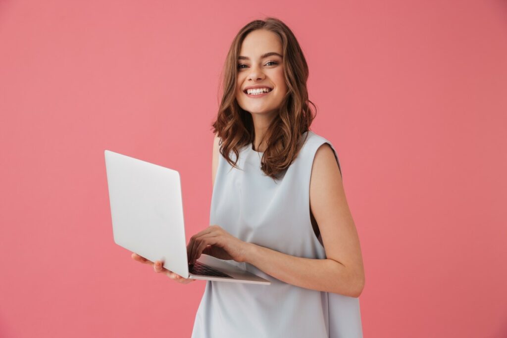 Woman smiling with laptop in her hand reading about how to find a job you love