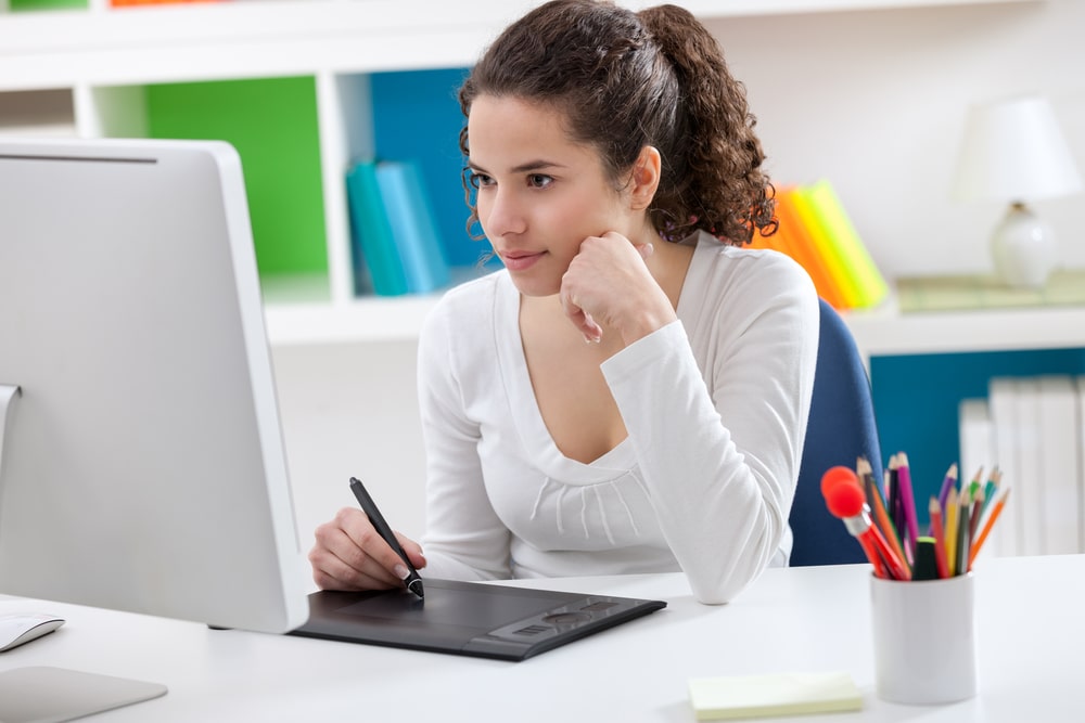 A pretty woman sits in front of her PC