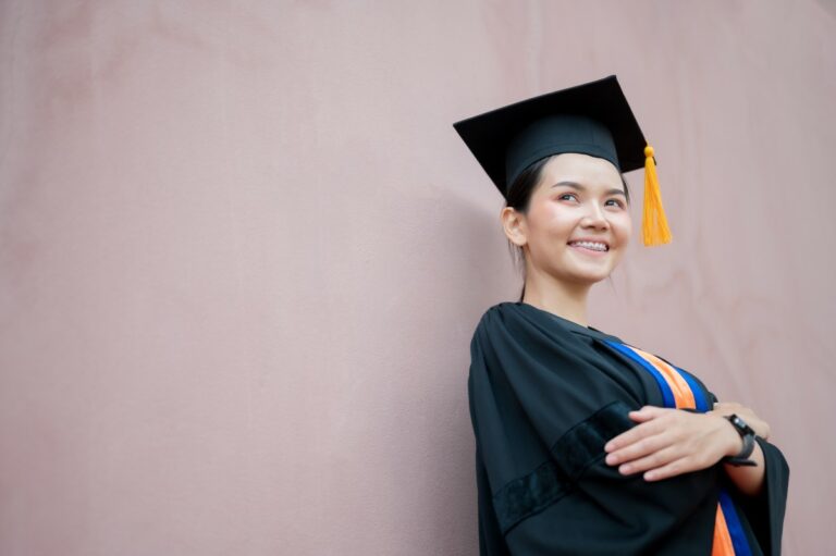 Woman smiling wearing an academic gown and cap - looking forward to get one of the top 10 highest paid bachelor degree jobs