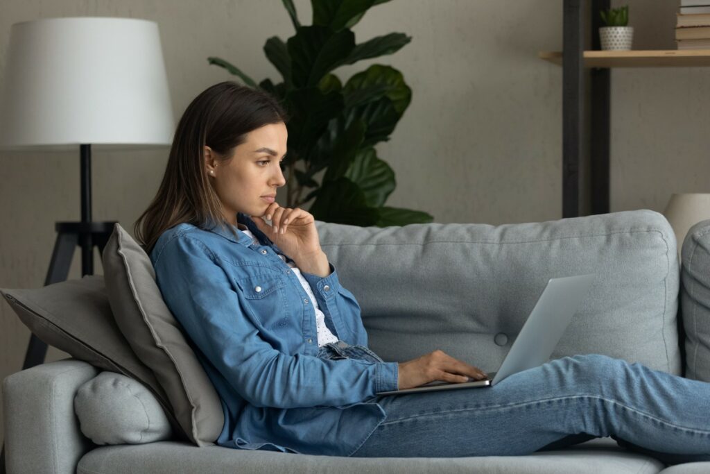 A Woman sitting on a couch starting writing a cover letter