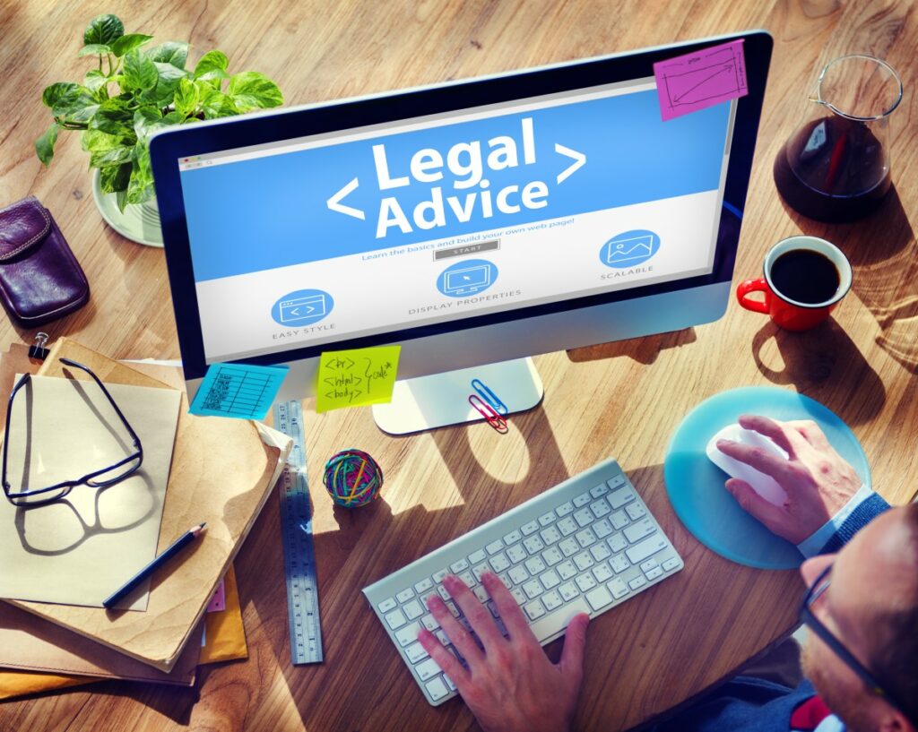 text <legal advice> shown on a srcreen on a desk with pen, ruler, keyboard, mouse, coffee etc.