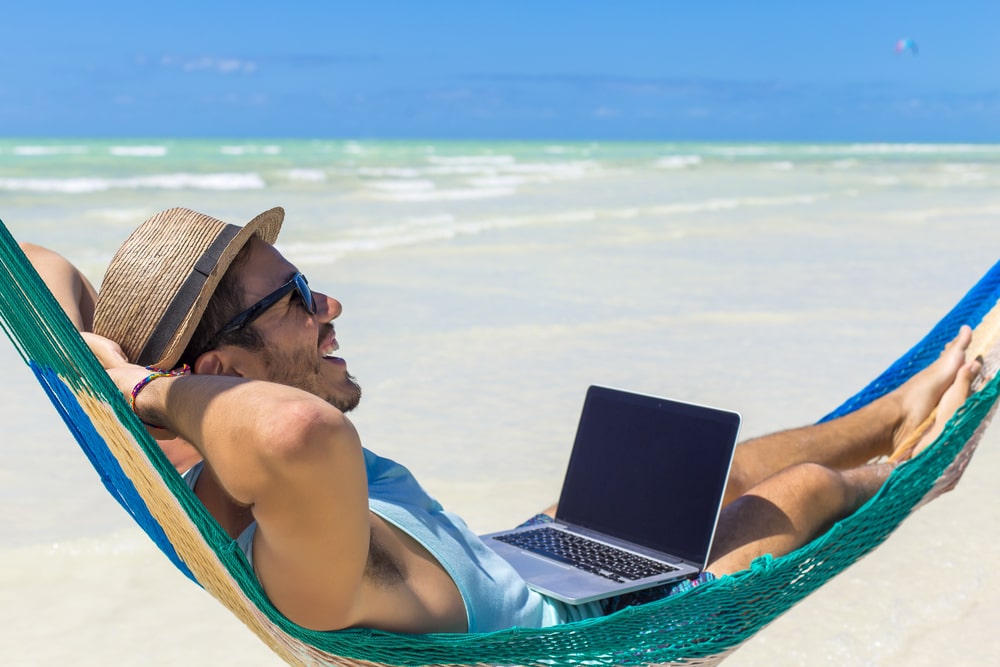 A man lies smiling in a hammock