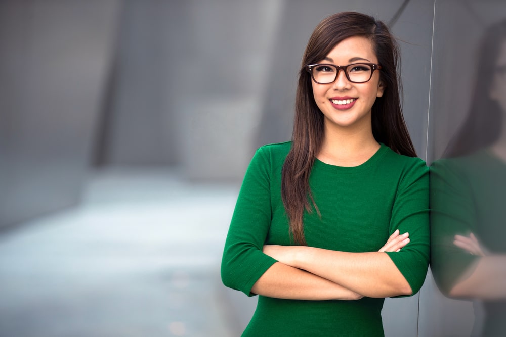 smiling asian woman in a green pullover