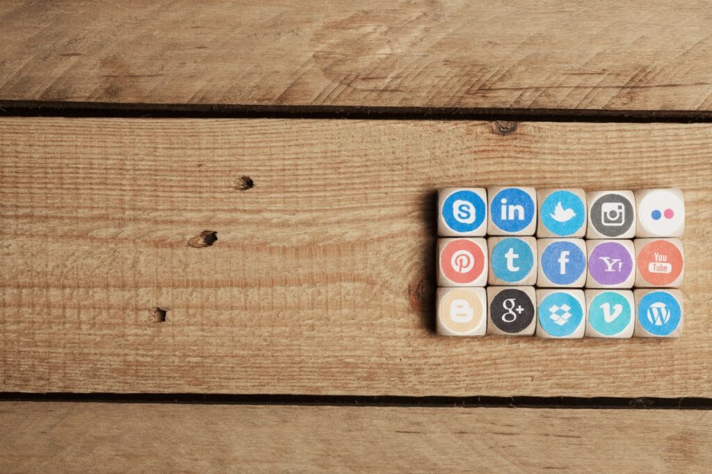 dice with printed on social media icons on a wooden table