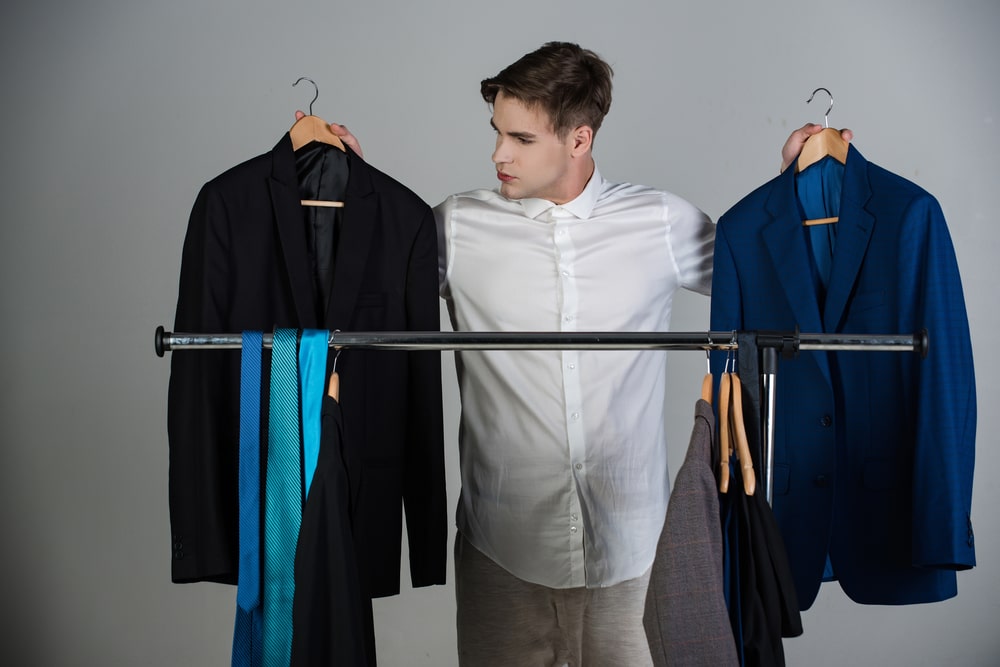 A man thinks about which outfit to choose for his online job interview