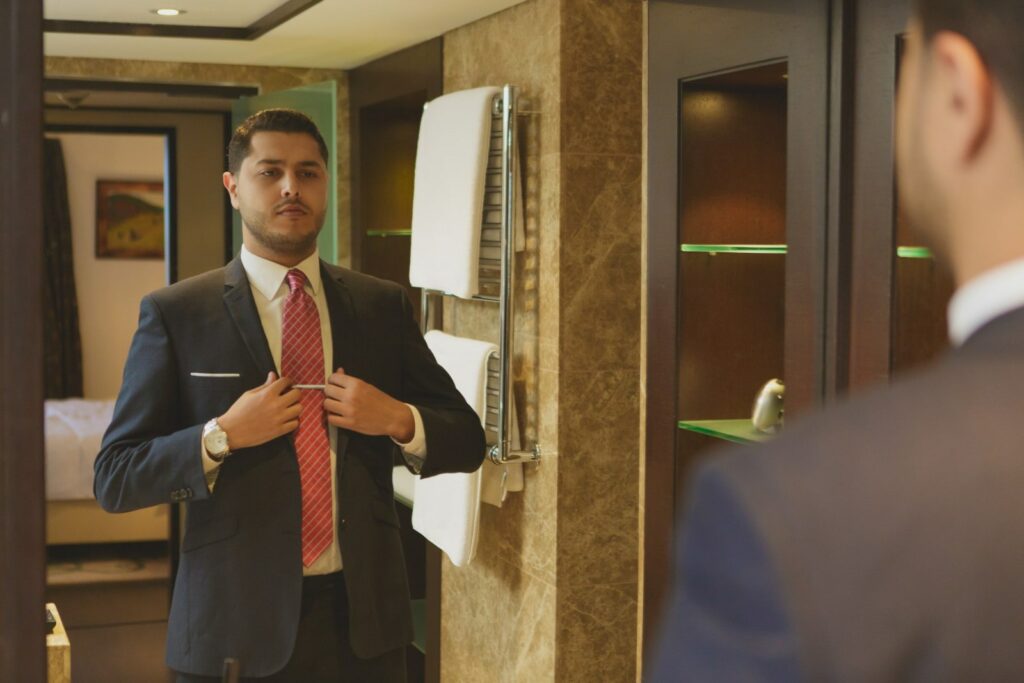 A man preparing his suit in the mirror for the job interview