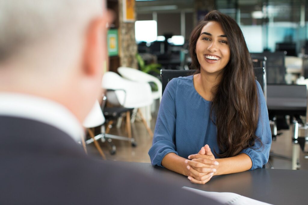 Woman sitting in front of a man smiling in the job interview