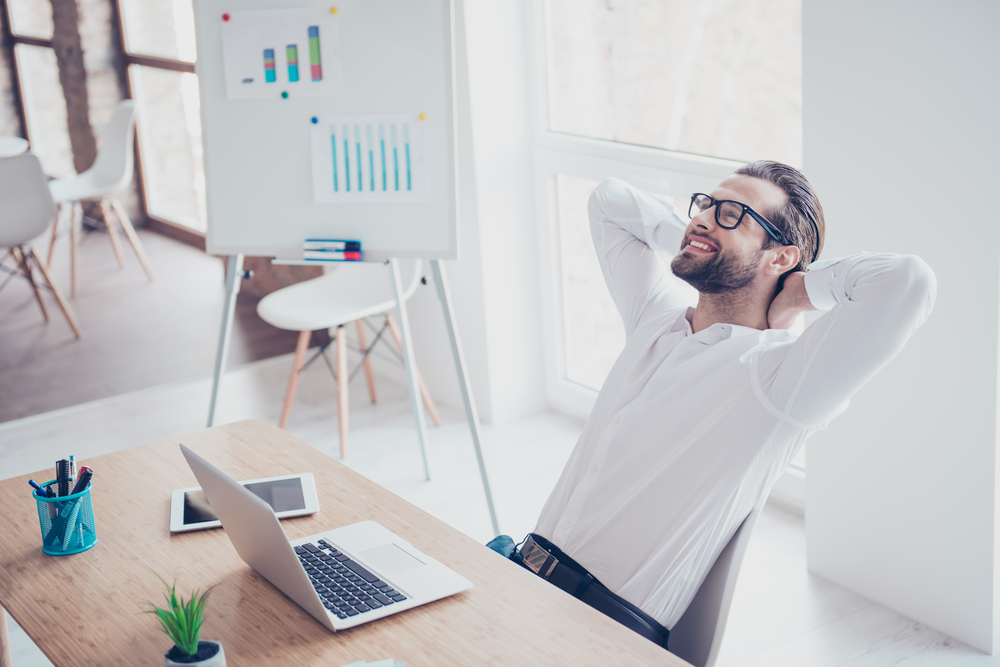 A businessman is smiling at the office after a long work day