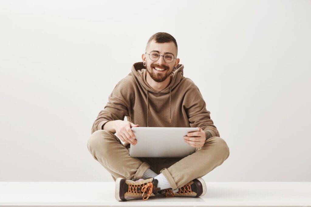 happy career starter sitting on the floor with a laptop