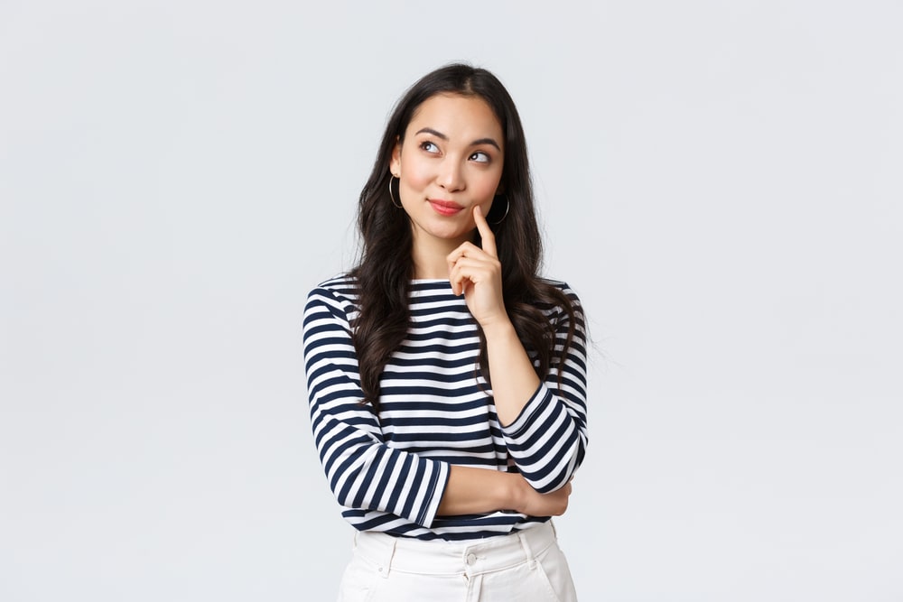 Business woman with thoughtful but positive face thinking about something pleasant