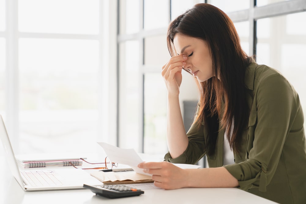 woman looks at her bill in despair