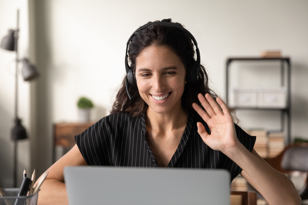 woman waving at laptop