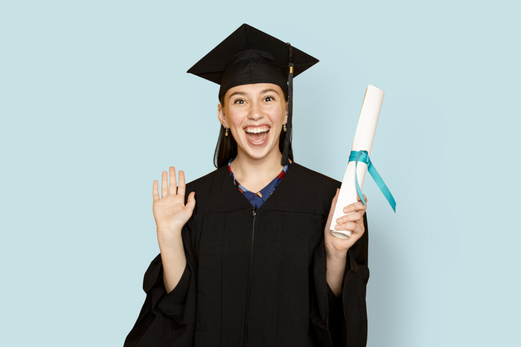 Female undergraduate student wearing a regalia and holding her degree