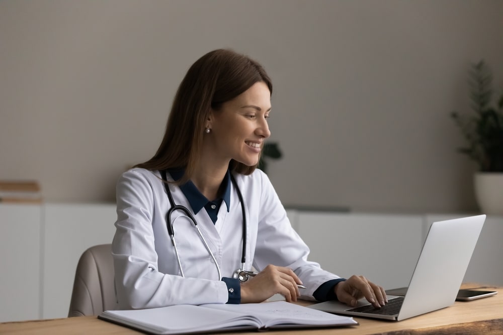 smiling young medical working on laptop