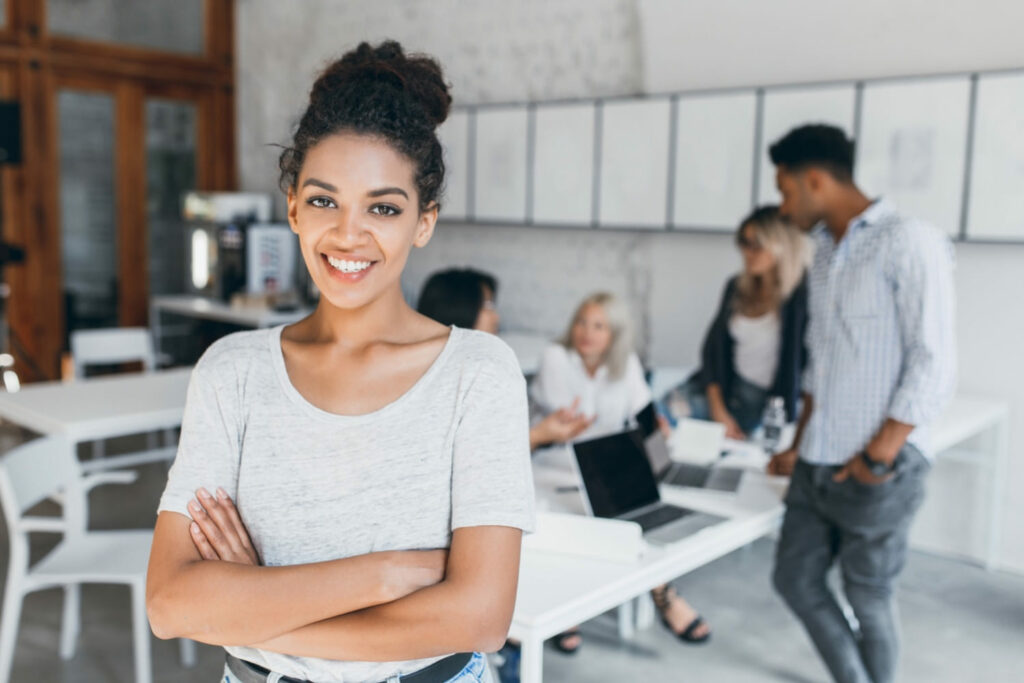 smiling young business woman standing in front of a room